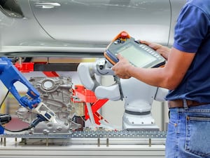 A technician use wireless remote for setting programm to order robotic maintenance car to work on automation