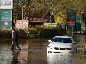 A white car on a flooded road