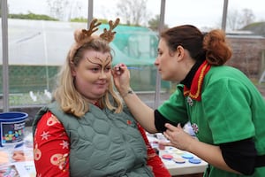 Student Lucy has her face painted by Sarah