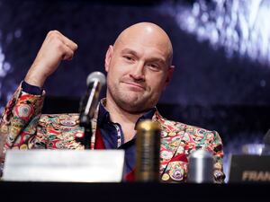 Tyson Fury holds his fist up at a press conference