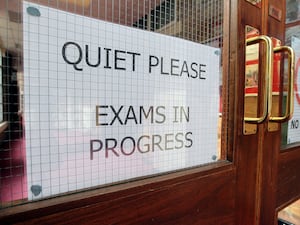 A sign asking for quiet as an exam is held