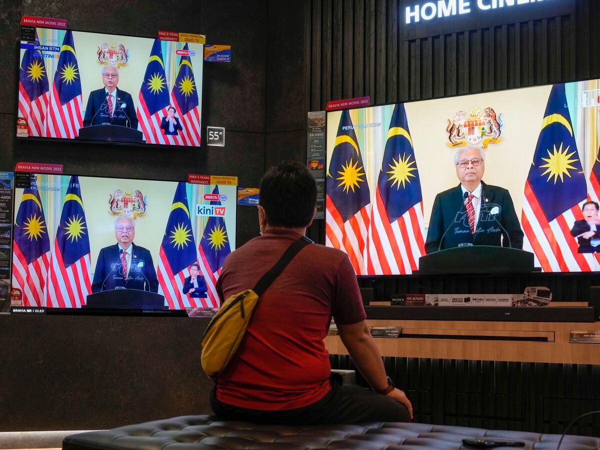 A man watches the live broadcast announced by PM Ismail Sabri Yaakob