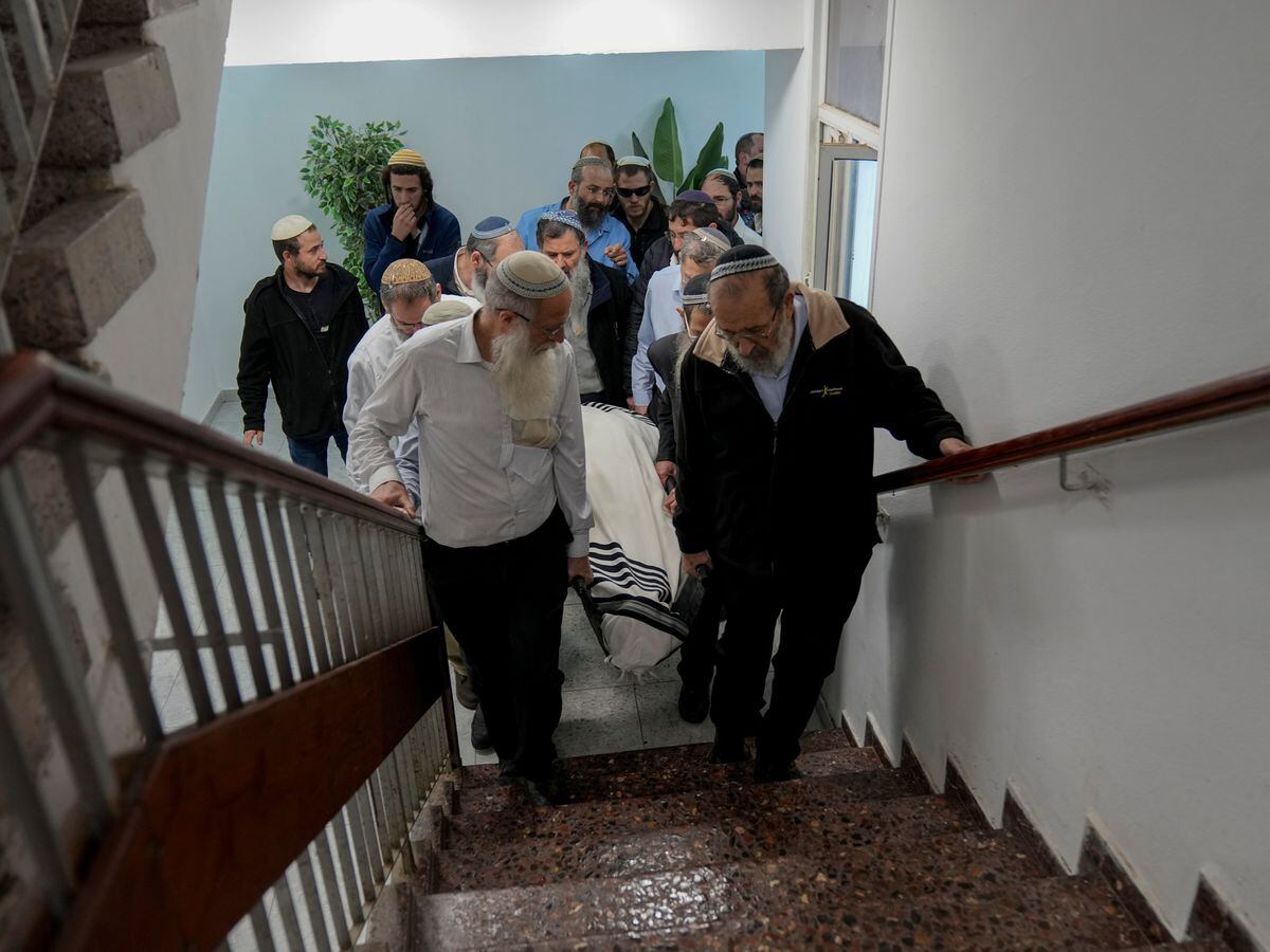 Mourners carry the body of Rabbi Haim Drukman during his funeral